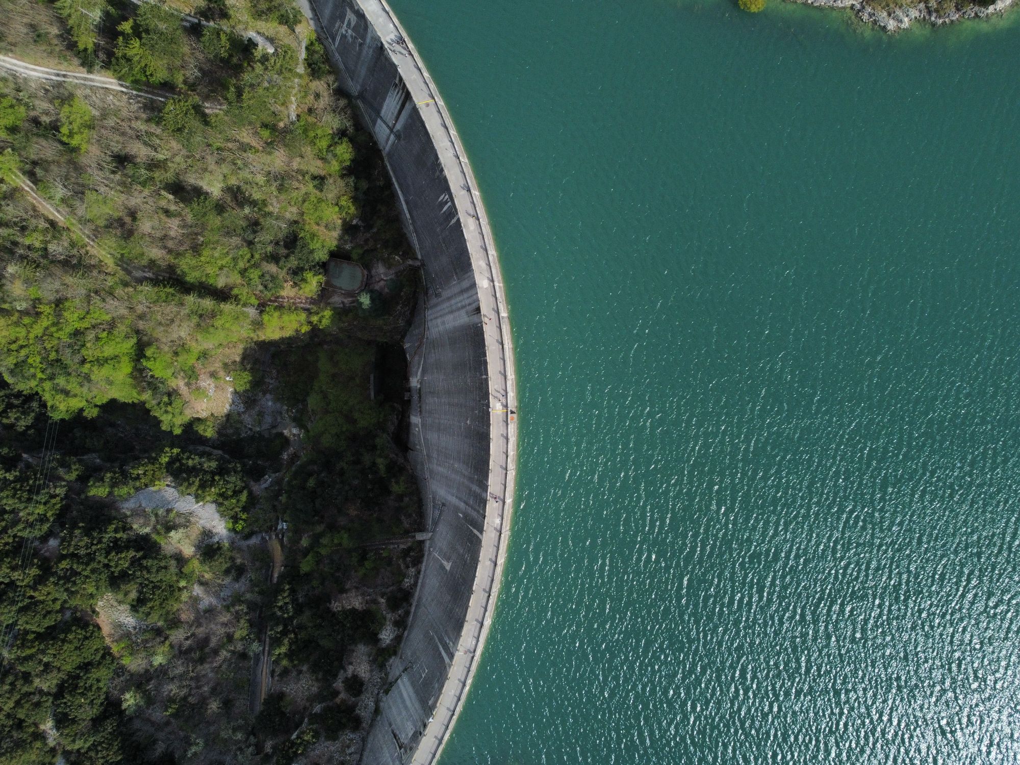 Vista aérea do paredão de uma barragem e da albufeira