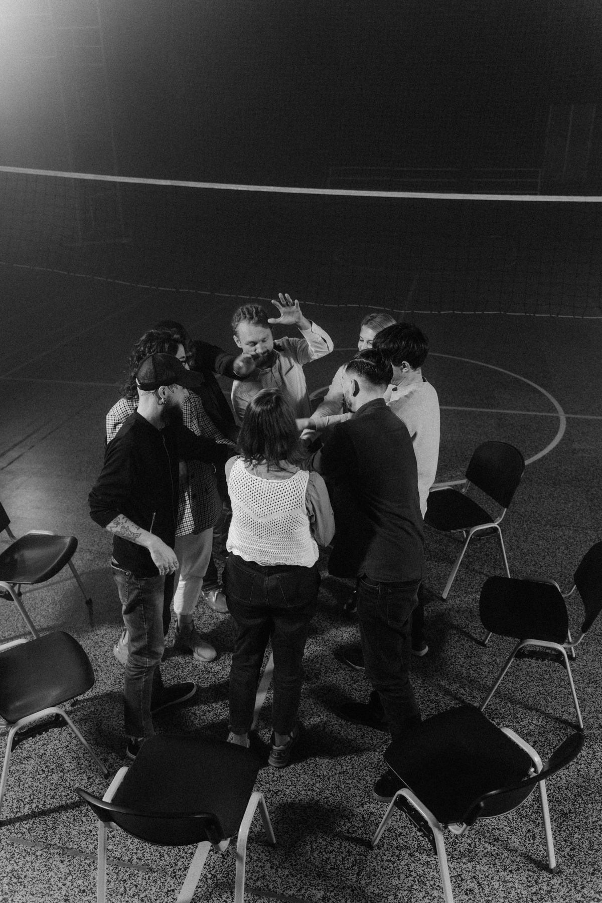 A group of people talking in a circle, in black and white