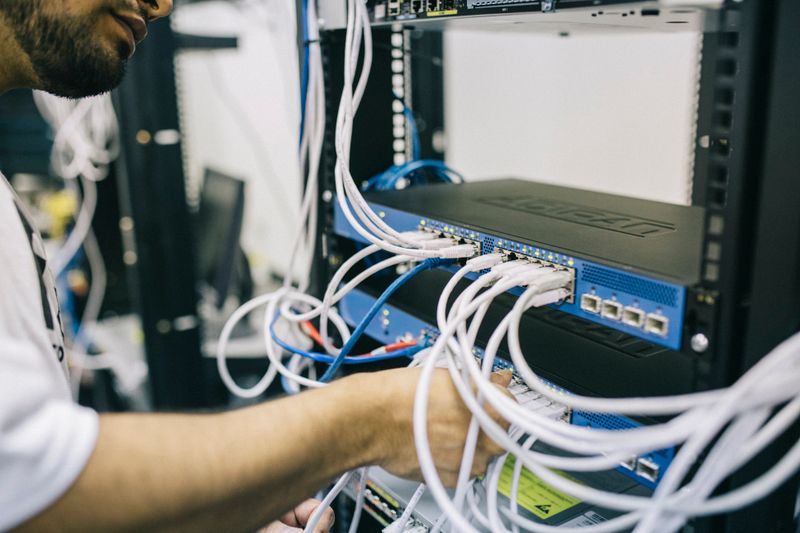 An IT professional connecting network cables in a server rack